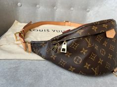 Overview Louis Vuitton Bum Bag in Canvas Monogram with gold hardware. Fashioned in classic Monogram canvas and signed with a “Louis Vuitton Paris” leather patch, this uber-functional bumbag transforms sportwear into the very definition of casual chic. Wear it as a belt bag, cross-body or over the shoulder for a jauntier look. Now discontinued this item is highly sought after. Features Monogram coated canvas Gold hardware Smooth cowhide leather trim Cotton canvas lining 1 main compartment with double zip closure 1 adjustable belt and top handle 1 D ring 1 natural cowhide leather patch Condition Exterior: Excellent condition with only light signs of wear. Minor marks to leather belt / strap. Slight wrinkling to strap. Interior: Excellent condition with minor marks. Hardware: Excellent condit Louis Vuitton Bum Bag, Louis Vuitton Bumbag, Louis Vuitton Paris, Classic Monogram, Louis Vuitton Shoes, Dior Shoes, Bum Bag, Vuitton Bag, Sierra Leone