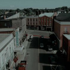 an overhead view of a city street with cars parked on both sides and buildings in the background