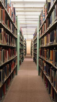 a long row of bookshelves filled with many different colored books in a library