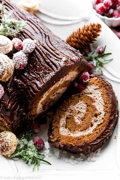 a chocolate cake with powdered sugar and cranberry toppings on a white plate