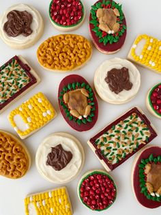 many decorated cookies are arranged on a white surface