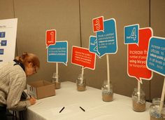 a woman standing over a table with some signs on it