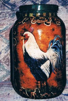 an orange jar with a rooster painted on it