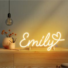 a neon sign that says,'enjoy'on top of a wooden shelf next to a vase with flowers