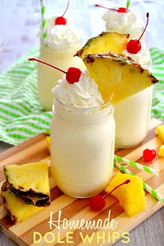 pineapple dole whip with whipped cream and cherries in mason jars on a cutting board