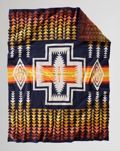 a blanket with an orange, yellow and blue design on the front is folded up