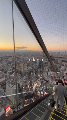 people walking up and down an escalator in tokyo, japan at sunset or dawn