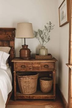 a bed room with a neatly made bed and two baskets on the side table next to it