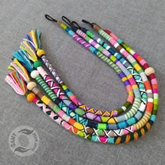 multicolored beaded necklace with tassels and wooden beads on grey background