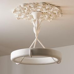 a white chandelier hanging from the ceiling in a room with flowers on it