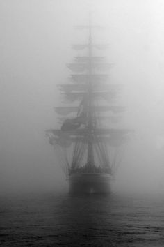 a tall ship in the middle of foggy water