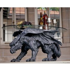 a table with a glass top that has a dragon on it and bottles in the background