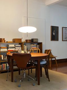 a dining room table and chairs with bookshelves in the background on a carpeted floor