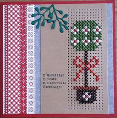 a cross stitch christmas card with a small tree on the front and red trimmings