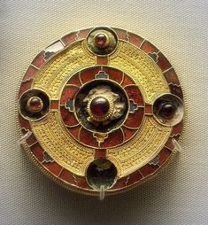 an ornate gold and red broochle on display