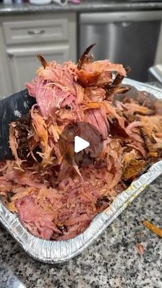 a metal pan filled with meat sitting on top of a counter