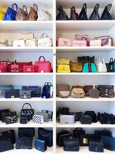 many purses and handbags are on shelves in a room with white shelving