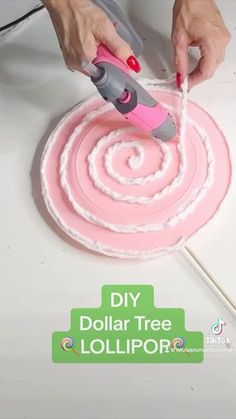 someone is using a pink and gray tool to decorate a cake