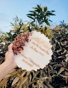 someone holding up a sign in front of some plants and trees with the words customized resinin on it