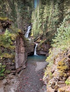 a small waterfall in the middle of a forest