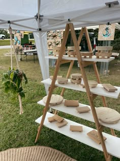 an outdoor display with wooden boards on it's shelves under a white tarp