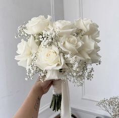 a person holding a bouquet of white flowers