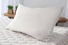 a white pillow sitting on top of a bed