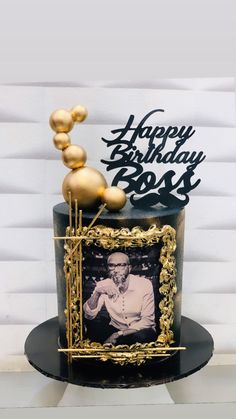 a black and gold birthday cake with a photo on top