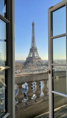 the eiffel tower is seen through an open door in front of a balcony