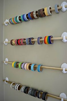 a wall mounted rack with many different colored ribbons on it