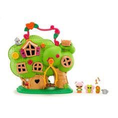 a green toy house with lots of toys around it on a white surface, including an apple tree