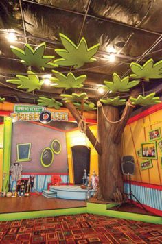 an indoor play area with trees and toys