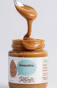 a jar of peanut butter with a spoon sticking out of it's top, on a white background