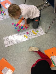 a group of children sitting on the floor playing with letters and numbers