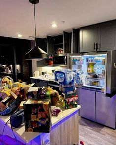 a kitchen filled with lots of food next to an open refrigerator and freezer door