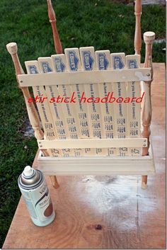 a wooden bench sitting on top of a field next to a spray bottle and brush