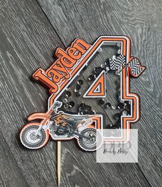 a cake topper with an image of a motorcycle and the number four on it