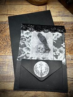 an envelope is decorated with black lace and a bird on it's front pocket