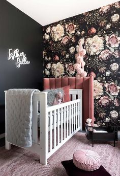 a baby's room with floral wallpaper and white crib in the foreground