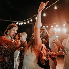 a group of people standing around each other on a dance floor with their arms in the air