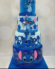 a three tiered blue and white cake with stitching on it