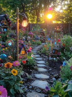 a garden filled with lots of flowers next to a wooden fence and light bulb lights