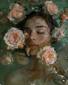 a woman with her eyes closed is surrounded by pink roses and water droplets on her face