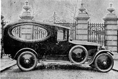 an old car parked in front of a gate