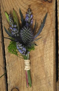 a bunch of flowers tied to a piece of wood