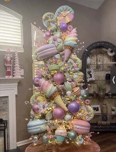 a decorated christmas tree with lots of balloons on it's top and decorations around the base