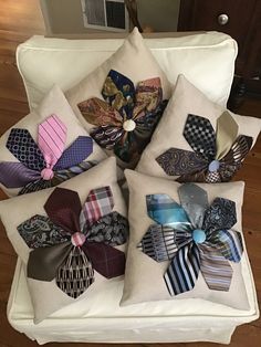 a bunch of different colored ties are on the back of a white chair with pillows