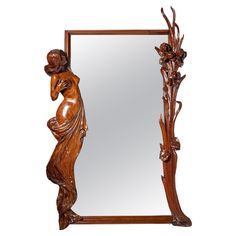 a wooden mirror with a woman holding a flower in her hand and an ornate frame around it