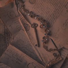 an old fashioned key is laying on top of some papers and other antique items that are scattered around it