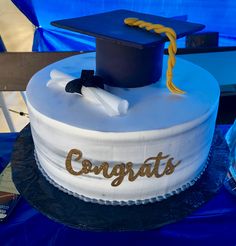 a graduation cake with the word congrats written on it and a mortar cap